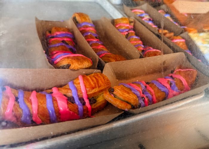 cheshire cat tail in Magic Kingdom park - a chocolate croissant with pink and purple drizzled icing